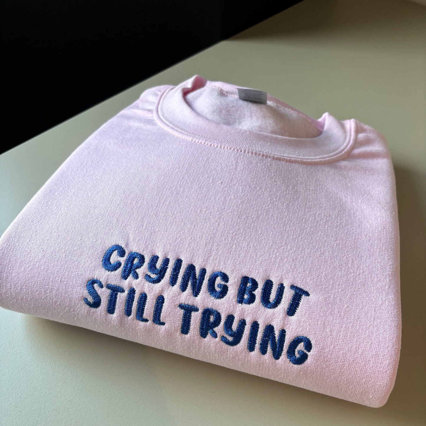 CRYING BUT STILL TRYING EMBROIDERED SWEATSHIRT