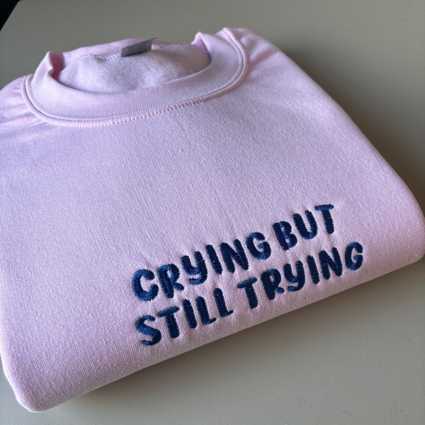 CRYING BUT STILL TRYING EMBROIDERED SWEATSHIRT