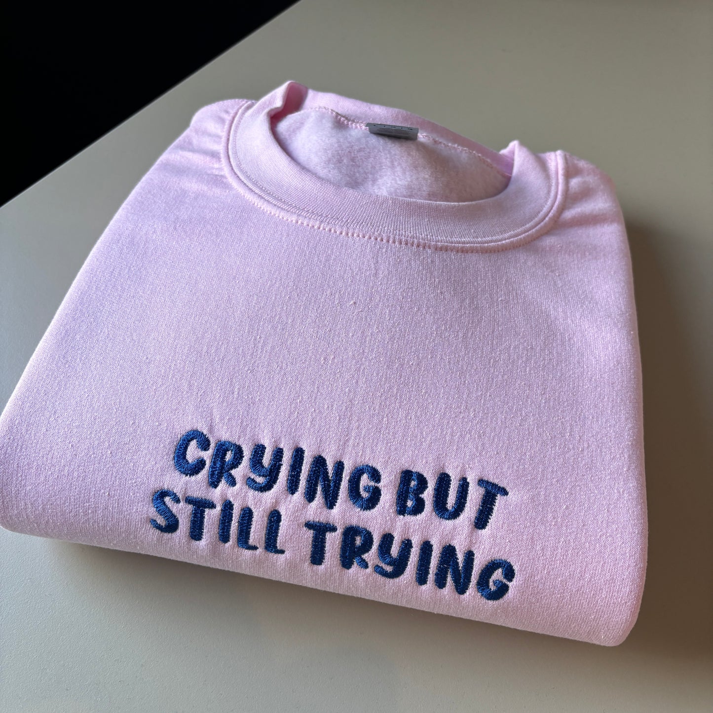 CRYING BUT STILL TRYING EMBROIDERED SWEATSHIRT