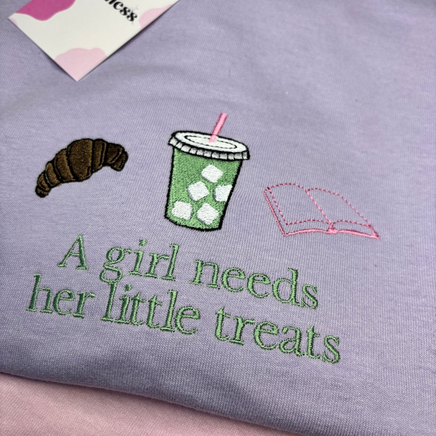 A GIRL NEEDS HER LITTLE TREATS EMBROIDERED SWEATSHIRT